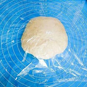 取出发好的面团，排出空气，盖上保鲜膜松弛15分钟