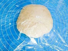 取出发好的面团，排出空气，盖上保鲜膜松弛15分钟