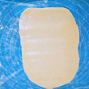 垫一层保鲜膜，面团放在保鲜膜上，上面再盖一层保鲜膜，擀成比土司盒略小的长方形，放入冰箱冷藏备用