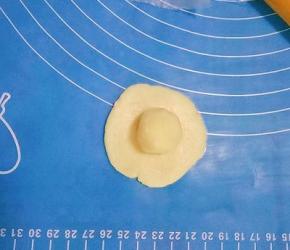 取一个油皮按扁擀成圆皮，放入一个油酥，收口