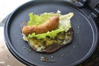 然后杂粮饼放上生菜，放上烤好的鱼肠，卷起来吃吧，外酥内软，非常有层次感，口感 很丰富的杂粮煎饼就做好了