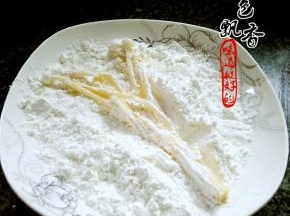 将沾上蛋液的金针菇裹上一层淀粉