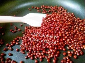 红豆倒入不粘锅内，开中小火，橡胶刮翻炒红豆2-3分钟，水分炒干，直到听到噼啪的爆皮声，立刻关火，移锅颜色，炒好的红豆黯淡发灰。
炒之前的红豆是鲜亮的红色。