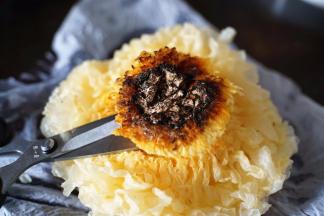 泡好的新银耳用剪刀减去根蒂黑色部分切割干净，用手将银耳捏碎，最好是每部分都能含有黄色的根部跟银耳的白色朵叶，这样做出来的银耳羹口感最佳哦！