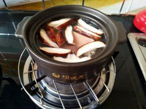 碗锅中放水，把香菇片，火腿片和豆腐泡放进去。