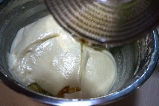 用刮刀翻拌均匀，将玉米油贴盆边倒入蛋糊中