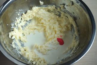 用电动打蛋器打成顺滑无颗粒状，再加入淡奶油及少许粉红色素