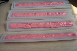 将夹心模具清洗干净擦干水，将裱花袋前端剪个小口，把奶酪糊挤入模具中，不要全部挤满，一端留出富余的空间