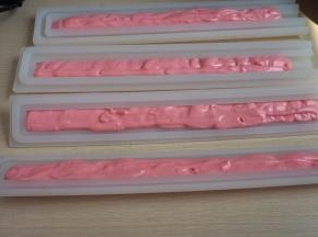 将夹心模具清洗干净擦干水，将裱花袋前端剪个小口，把奶酪糊挤入模具中，不要全部挤满，一端留出富余的空间