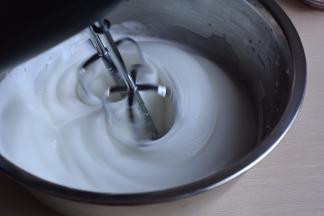 打到蛋白呈现细腻白色状时，加入20克白糖