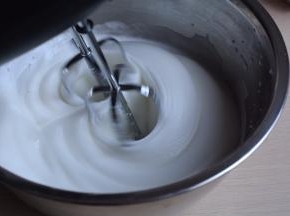 打到蛋白呈现细腻白色状时，加入20克白糖