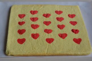 5分钟后，将蛋糕翻面，撕去原来底部的油纸，看，颗颗红心显出来了；将干净的油纸覆盖在表面