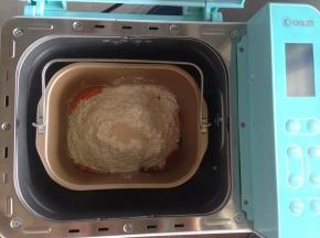 在面粉上端放入酵母。将面包桶放入到面包机内