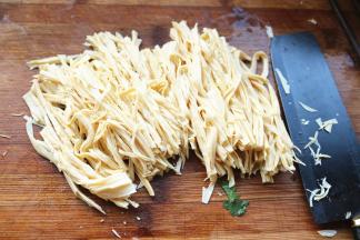 沥干水分的腐竹切成细条。