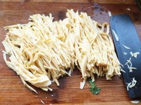 沥干水分的腐竹切成细条。