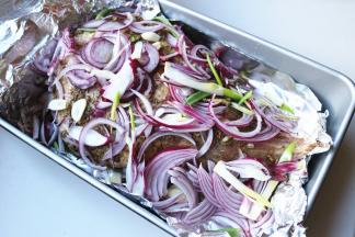 把剩余的洋葱丝和蒜片铺在羊腿上面。