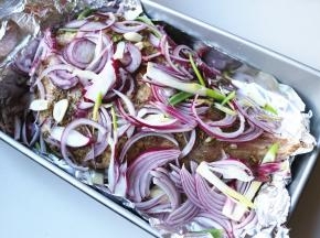 把剩余的洋葱丝和蒜片铺在羊腿上面。