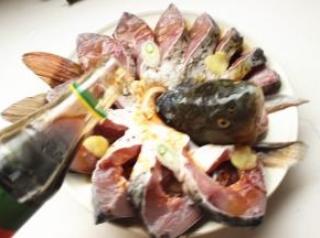 鱼身上再放几片姜片和葱段，再加蒸鱼豉油，尽量均匀。