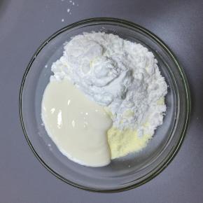 酸奶倒入碗里，奶粉和玉米淀粉过筛倒在一起