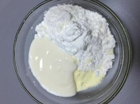 酸奶倒入碗里，奶粉和玉米淀粉过筛倒在一起