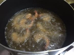 9. 锅里坐油烧至能看见鱼泡眼之后调至小火，码入虾，炸至金黄色即可