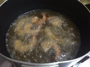 9. 锅里坐油烧至能看见鱼泡眼之后调至小火，码入虾，炸至金黄色即可