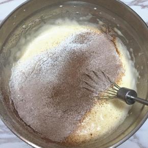 筛入低筋面粉和可可粉的混合物，用刮刀小心地从底部往上翻拌，使蛋糊和面粉混合均匀，不要画圈搅拌，以免消泡