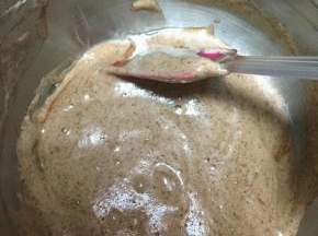 将牛奶和玉米油的混合物缓缓从边缘倒入蛋糊中