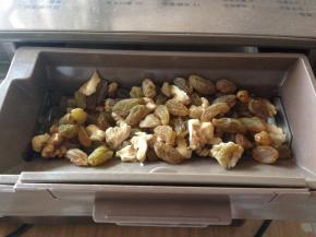 将核桃仁和葡萄干放入面包机的果料盒里