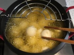 汤圆倒入油锅内，要不停翻，注意不要让汤圆粘在一起