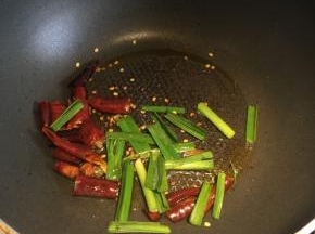 另起炒菜锅，倒入一点点油，先下干辣椒和蒜苗爆香