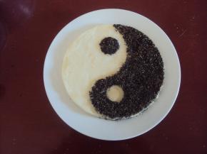 取出，在果味的一半太极上撒上拌匀的芝麻和葡萄干碎，用平板压一下