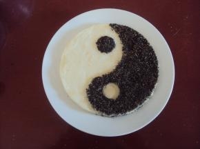 取出，在果味的一半太极上撒上拌匀的芝麻和葡萄干碎，用平板压一下