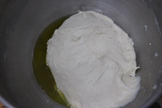 启动厨师机1档和面，揉至大约十分钟。面团成团并且有韧性，加入橄榄油，继续和面。