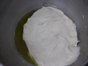 启动厨师机1档和面，揉至大约十分钟。面团成团并且有韧性，加入橄榄油，继续和面。