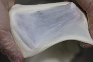 面团吸收橄榄油后，换2档继续和面，揉至面团拉出薄而坚韧的面膜，结束揉面。