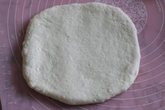 用面杖把面团擀平，尽量擀成厚度相同的四角型。