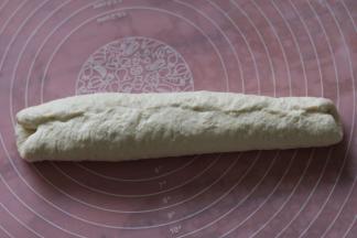 把两结合处捏在一起，压紧，滚成不粗细均匀的长型法国面包形状。