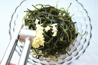 蒜和姜用压蒜器压成末放在海带丝上面。