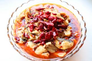 把水煮鱼料包里的干料包放放上香菜和葱末。在鱼肉上面。