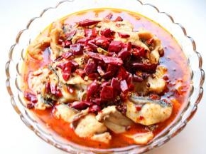 把水煮鱼料包里的干料包放放上香菜和葱末。在鱼肉上面。