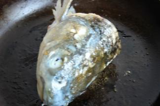 平底锅放花生油，煎香鱼头，各个面都煎到。