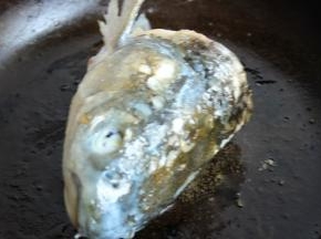 平底锅放花生油，煎香鱼头，各个面都煎到。