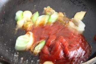 鱼头先移入汤锅内，剩下葱姜，放入茄汁酱翻炒。