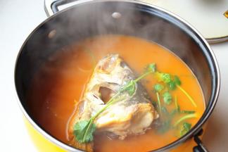 煮好的鱼头汤，放入芝麻油和香菜调味
