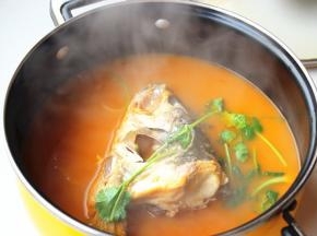 煮好的鱼头汤，放入芝麻油和香菜调味