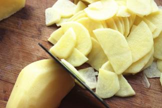 先竖切一下，再切薄片，如果是细长的土豆就可以直接切片了。