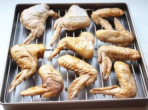 腌好的鸡翅均匀摆在烤架上，烤架放入烤盘。