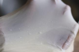 启动厨师机1档和面功能，面团成团后转2档继续揉面。大约15分钟揉至面团扩展阶段加入黄油，继续揉面。揉至如图完全阶段即可。