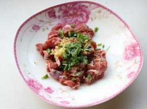 葱姜切末，加到羊肉里，再加少许色拉油和五香粉。